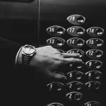 Are You Overpaying for Elevator Phone Lines? 4 elevator control panel with man touching buttons